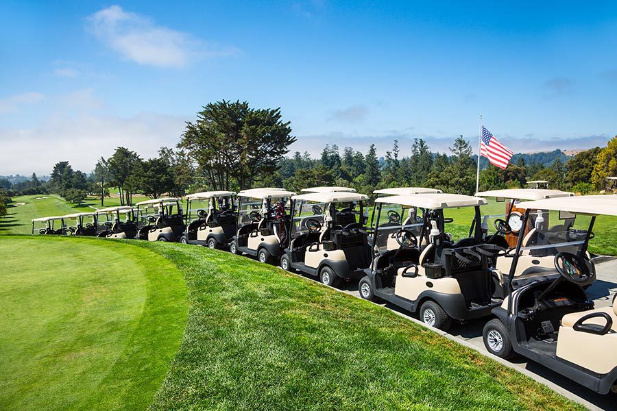 Specialized Business Insurance - Golf Carts Lined Up Outside Under the Sun, On a Path Overlooking a Golf Course